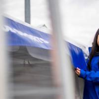 An alum laughs next to a Reunion Row tent